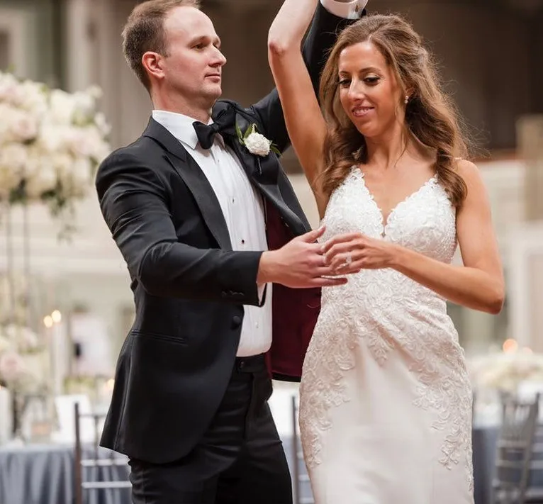 A groom twirls his bride on the dance floor